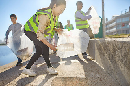 simsearch:859-06808649,k - Woman volunteer picking up plastic litter on sunny boardwalk Stock Photo - Premium Royalty-Free, Code: 6113-09240204