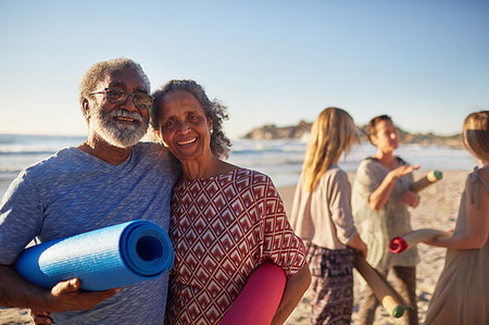 simsearch:6113-06754093,k - Portrait happy senior couple with yoga mats on sunny beach during yoga retreat Foto de stock - Sin royalties Premium, Código: 6113-09240492