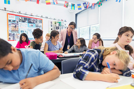 simsearch:6113-07731249,k - Female teacher helping junior high school girl students doing homework at desk in classroom Stock Photo - Premium Royalty-Free, Code: 6113-09240410