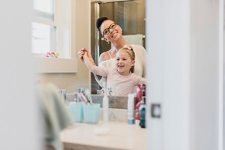 Smiling mother and daughter in bathroom mirror Foto de stock - Sin royalties Premium, Código: 6113-09240800