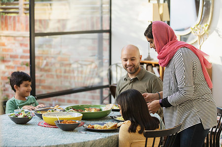 simsearch:614-05650637,k - Mother in hijab serving dinner to family at dining table Stock Photo - Premium Royalty-Free, Code: 6113-09241050