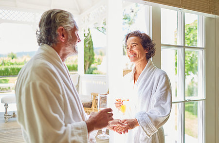 simsearch:6113-07242393,k - Happy mature couple in bathrobes drinking mimosas at hotel balcony doorway Stock Photo - Premium Royalty-Free, Code: 6113-09241155