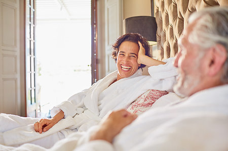 simsearch:6113-07242393,k - Happy, laughing mature couple relaxing on hotel bed Stock Photo - Premium Royalty-Free, Code: 6113-09241195