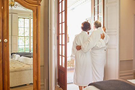 simsearch:6113-07242393,k - Mature couple in spa bathrobes standing at hotel balcony doorway Stock Photo - Premium Royalty-Free, Code: 6113-09241210