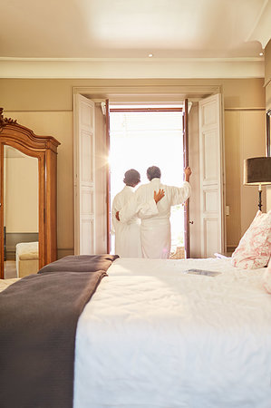 simsearch:628-07072151,k - Affectionate couple in spa bathrobes standing at hotel balcony doorway Stock Photo - Premium Royalty-Free, Code: 6113-09241225