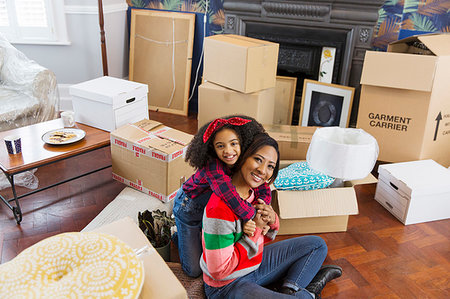 simsearch:6108-06167233,k - Portrait happy, affectionate mother and daughter hugging among boxes, moving house Photographie de stock - Premium Libres de Droits, Code: 6113-09241304