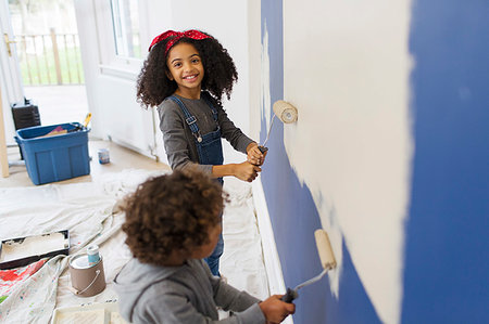 simsearch:6113-07147136,k - Portrait happy girl painting wall with brother Stock Photo - Premium Royalty-Free, Code: 6113-09241312