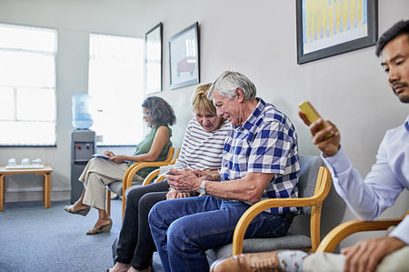 simsearch:6113-06720636,k - Senior couple using smart phone in clinic waiting room Stock Photo - Premium Royalty-Free, Code: 6113-09241493