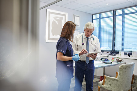 simsearch:6113-06720636,k - Doctor and nurse with digital tablet talking, consulting in clinic doctors office Stock Photo - Premium Royalty-Free, Code: 6113-09241558