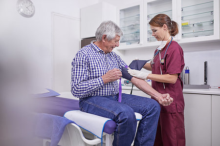simsearch:6113-07146704,k - Female nurse checking blood pressure of senior male patient in clinic examination room Foto de stock - Sin royalties Premium, Código: 6113-09241580