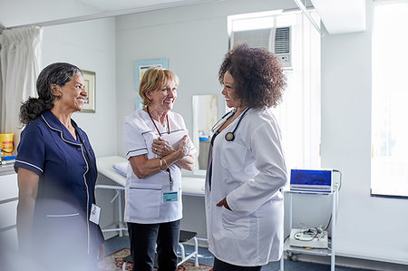 simsearch:6113-07146794,k - Female doctor and nurses talking in clinic examination room Stock Photo - Premium Royalty-Free, Code: 6113-09241594