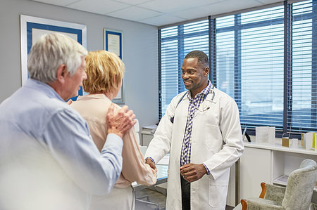 Doctor shaking hands with senior couple in doctors office Stock Photo - Premium Royalty-Free, Code: 6113-09241518