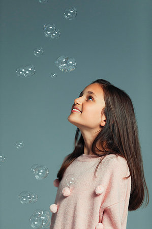 simsearch:695-03376367,k - Happy, curious girl watching falling bubbles Stock Photo - Premium Royalty-Free, Code: 6113-09272491