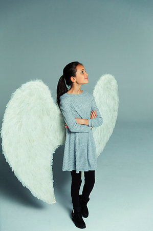 simsearch:693-06435933,k - Portrait confident, curious girl wearing angel wings, looking up Stock Photo - Premium Royalty-Free, Code: 6113-09272502