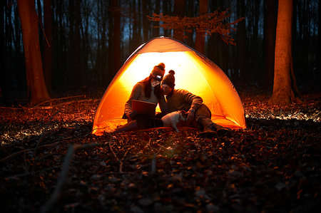 simsearch:6113-06720867,k - Couple using digital tablet inside glowing tent in woods at night Stock Photo - Premium Royalty-Free, Code: 6113-09272518