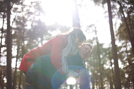 simsearch:649-07280823,k - Happy, playful couple piggybacking in sunny, autumn woods Stock Photo - Premium Royalty-Free, Code: 6113-09272538