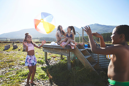 simsearch:6113-06909382,k - Playful lesbian couple and kids with beach ball at remote, sunny, summer poolside Stock Photo - Premium Royalty-Free, Code: 6113-09272771