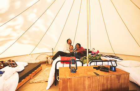 Happy, carefree family relaxing on bed in camping yurt Stock Photo - Premium Royalty-Free, Code: 6113-09272868