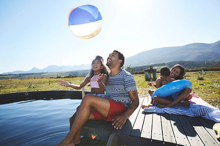 simsearch:6113-06909382,k - Playful family with beach ball at sunny, summer swimming pool Stock Photo - Premium Royalty-Free, Code: 6113-09272870