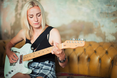 simsearch:614-06719795,k - Young woman playing electric guitar on sofa Stock Photo - Premium Royalty-Free, Code: 6113-09220494