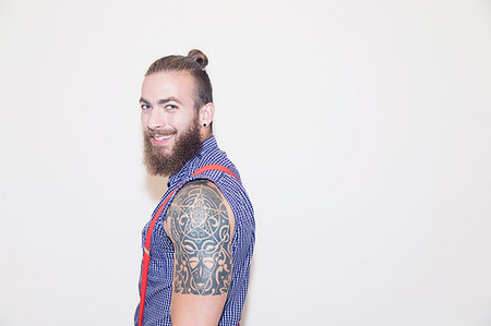 Portrait confident male hipster with shoulder tattoo Stock Photo - Premium Royalty-Free, Code: 6113-09220503