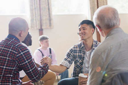 simsearch:700-01195953,k - Men shaking hands in group therapy in community center Stock Photo - Premium Royalty-Free, Code: 6113-09220697