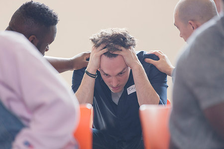 Men comforting upset man in group therapy Stock Photo - Premium Royalty-Free, Code: 6113-09220694