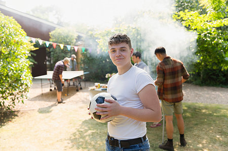 football in the backyard - Portrait confident teenage boy with soccer ball, enjoying backyard barbecue Stock Photo - Premium Royalty-Free, Code: 6113-09239769