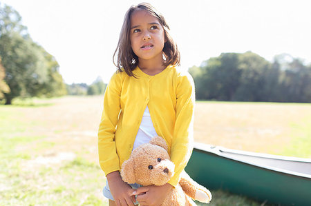 simsearch:649-06533379,k - Girl with teddy bear in sunny field with canoe Photographie de stock - Premium Libres de Droits, Code: 6113-09239895