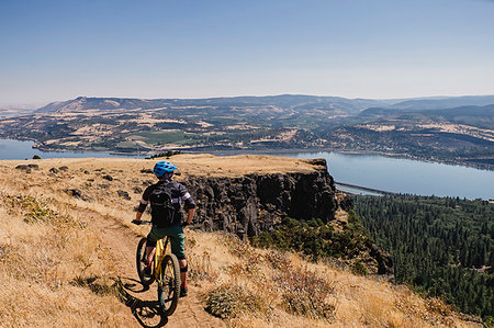 Man mountain biking, enjoying Columbia River view from cliff, Hood River, Oregon, USA Stock Photo - Premium Royalty-Free, Code: 6113-09239826