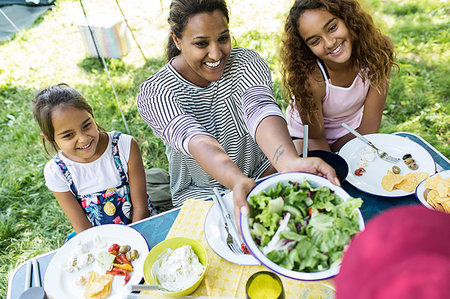 simsearch:614-07806265,k - Happy mother and daughters enjoying salad lunch at campsite table Stock Photo - Premium Royalty-Free, Code: 6113-09239949