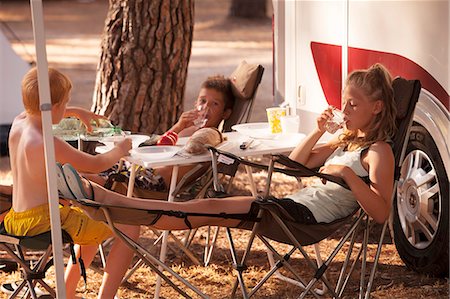 Croatia, Dalmatia, Children Relaxing In Front Of Camp Trailer Stock Photo - Premium Royalty-Free, Code: 6115-06732840