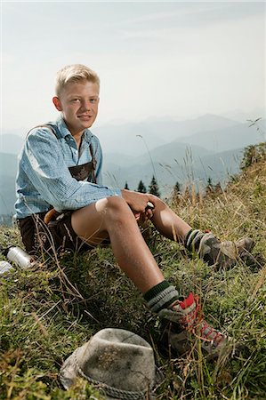 Germany, Bavaria, Boy in traditional clothing taking a rest in mountains Foto de stock - Sin royalties Premium, Código: 6115-06733159