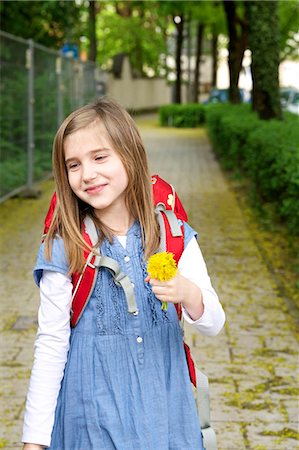 education and back to school - Little girl walking home from school, holding a flower, Munich, Bavaria, Germany Photographie de stock - Premium Libres de Droits, Code: 6115-07109654