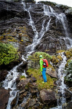 Hiker taking a look at waterfall, Norway, Europe Stock Photo - Premium Royalty-Free, Code: 6115-07109755
