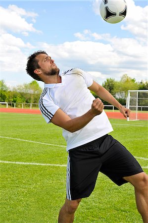 Soccer player bouncing ball on head, Munich, Bavaria, Germany Stock Photo - Premium Royalty-Free, Code: 6115-07109911