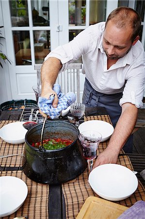 simsearch:6115-07282765,k - Man Is Stirring Food In Cooking Pot Stock Photo - Premium Royalty-Free, Code: 6115-07282763
