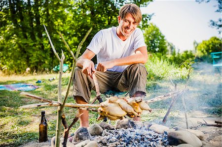 foothill - Young man barbecuing on the riverside, foothills of the Alps, Bavaria, Germany Stock Photo - Premium Royalty-Free, Code: 6115-07282798