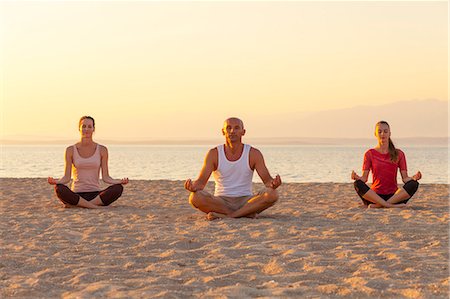 simsearch:640-03265635,k - People practising yoga on beach, lotus pose Stock Photo - Premium Royalty-Free, Code: 6115-07539715