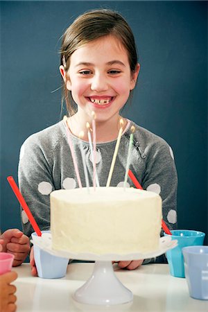 simsearch:6115-06778498,k - Girl on birthday party looking at candles on cake, Munich, Bavaria, Germany Stock Photo - Premium Royalty-Free, Code: 6115-08066272