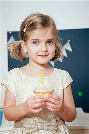 simsearch:6115-06778498,k - Girl on birthday party holding cupcake wit burning candle, Munich, Bavaria, Germany Stock Photo - Premium Royalty-Free, Code: 6115-08066237