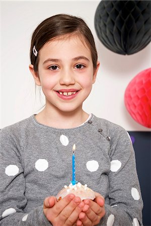 simsearch:6115-06778498,k - Girl on birthday party holding cupcake with burning candle, Munich, Bavaria, Germany Stock Photo - Premium Royalty-Free, Code: 6115-08066234