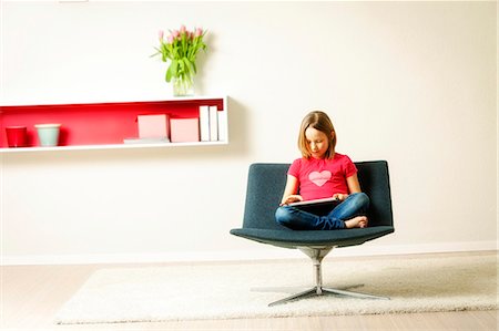 simsearch:649-07064267,k - Girl sits in chair using tablet computer, Munich, Bavaria, Germany Stock Photo - Premium Royalty-Free, Code: 6115-08066350