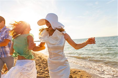 Bride and girlfriend dancing on the beach, Dalmatia, Croatia Stock Photo - Premium Royalty-Free, Code: 6115-08066323