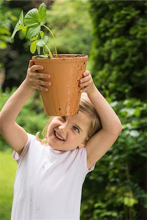 simsearch:6115-07539732,k - Little girl gardening, holding potted plant in hands Stock Photo - Premium Royalty-Free, Code: 6115-08100444