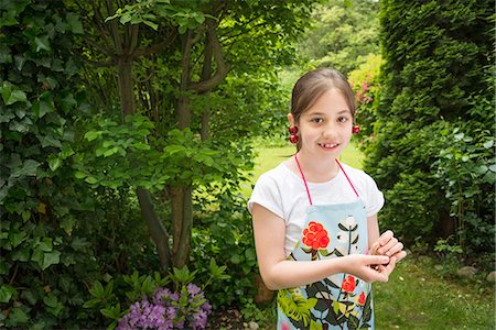 simsearch:6115-07539732,k - Girl in garden, cherries dangling from her ears Stock Photo - Premium Royalty-Free, Code: 6115-08100454