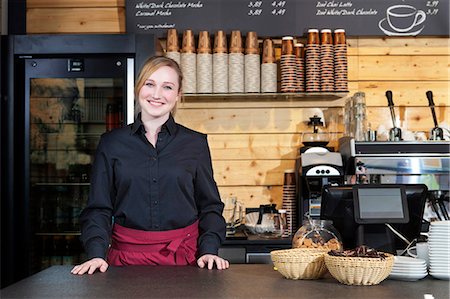 Shop assistant standing behind counter in coffee shop Stock Photo - Premium Royalty-Free, Code: 6115-08100524