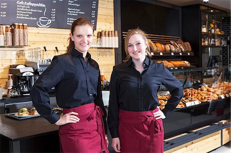 Female shop assistants in coffee shop standing side by side Stock Photo - Premium Royalty-Free, Code: 6115-08100525