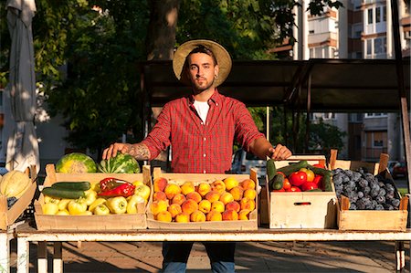 simsearch:6115-06732928,k - Young man selling fruit and vegetables at market stall Stock Photo - Premium Royalty-Free, Code: 6115-08100792