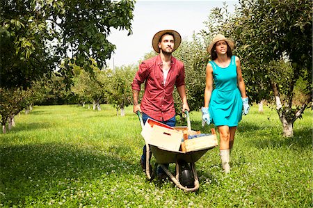 simsearch:6115-06732928,k - Young couple with wheelbarrow in orchard Stock Photo - Premium Royalty-Free, Code: 6115-08100804